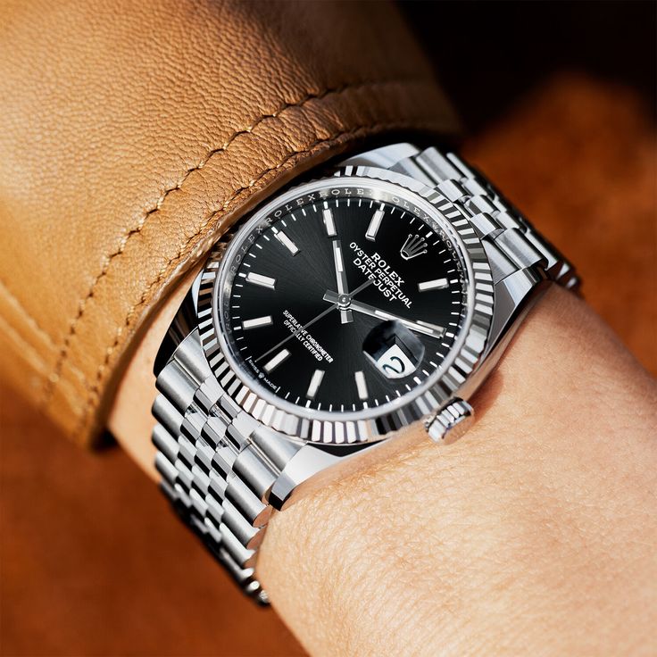 Ispirazione di stile: orologio con quadrante nero e bracciale in acciaio indossato al polso